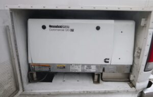 White Cummins Onan commercial generator in compartment.