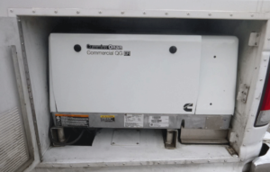 White Cummins Onan commercial generator in compartment.