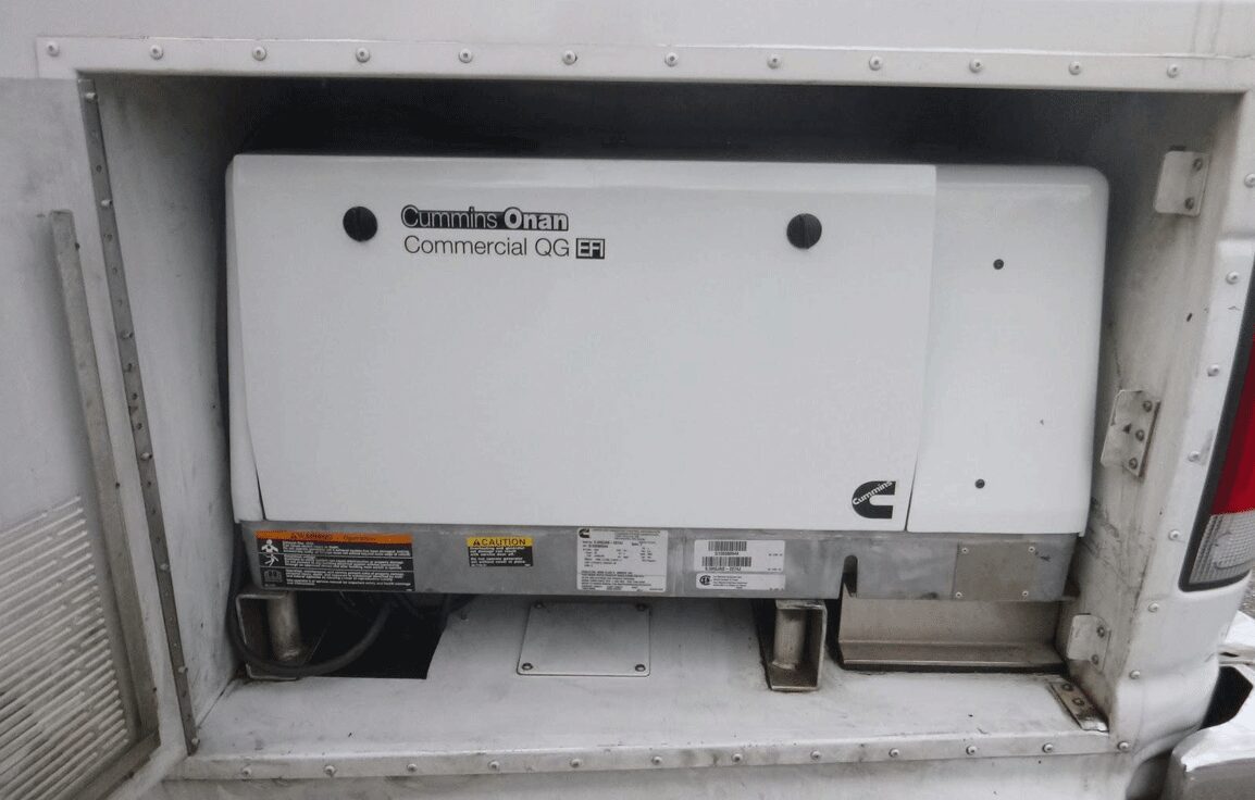 White Cummins Onan commercial generator in compartment.