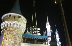 Castle turrets illuminated at night, dark sky.
